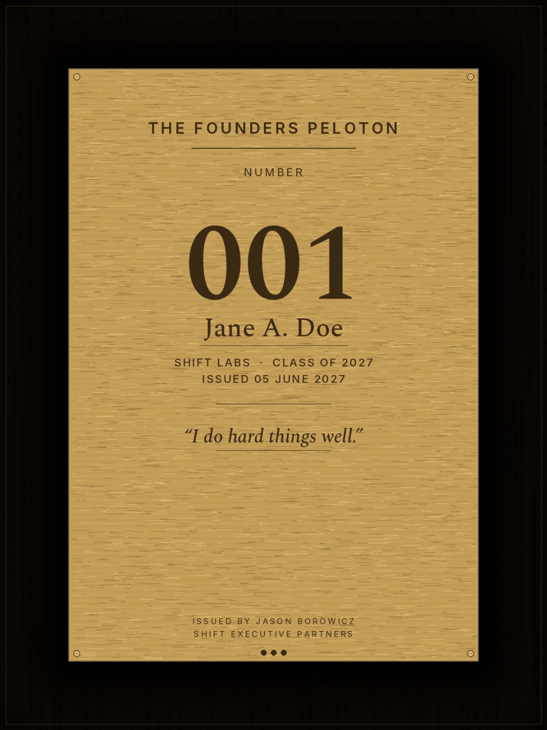 The Founders Peloton — walnut plaque with brushed brass plate. Reads: Number 001, Jane A. Doe, Shift Labs · Class of 2027, Issued 05 June 2027. Engraved creed: I do hard things well. Issued by Jason Borowicz, Shift Executive Partners.